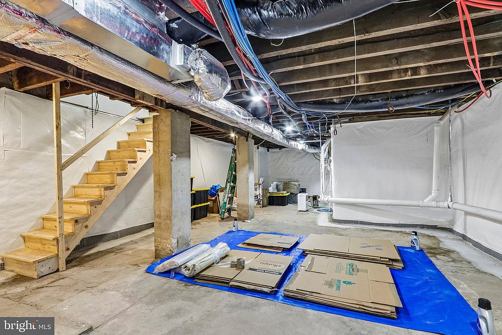 Photo 42 — Basement, stairs (tarps are moving-day staging)